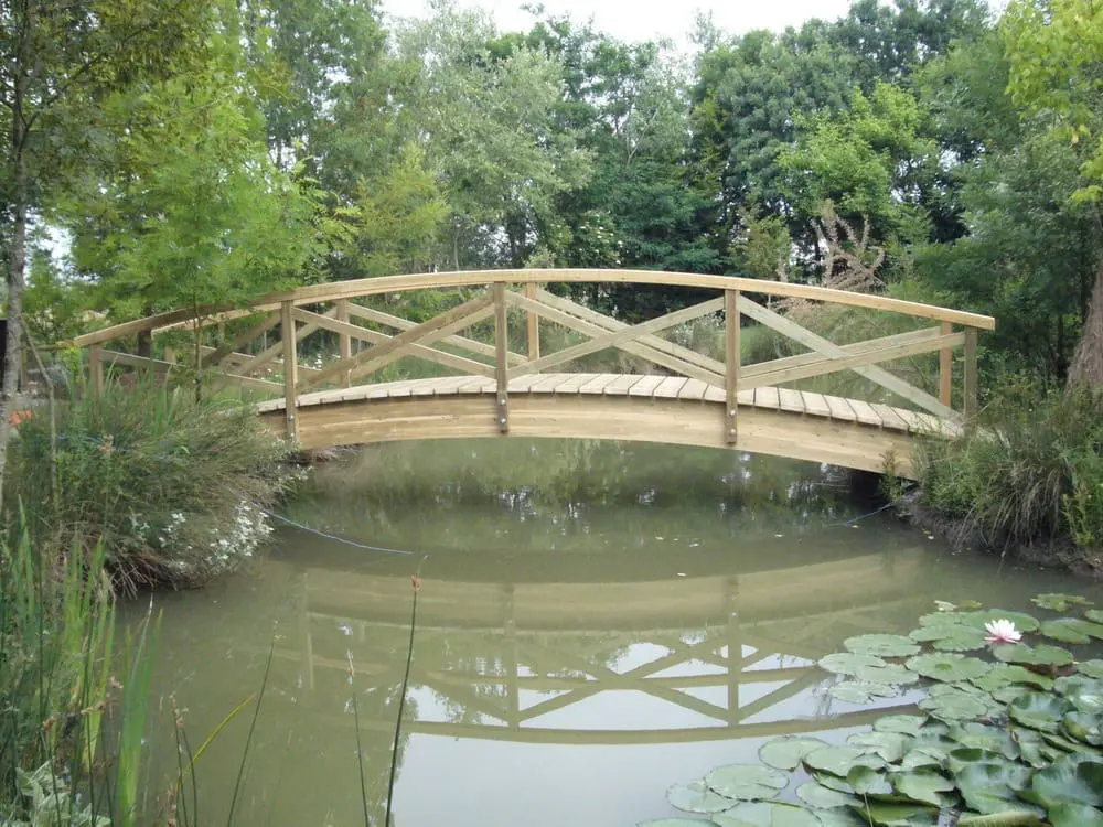 Pont en bois en pin sur plan d’eau arboré