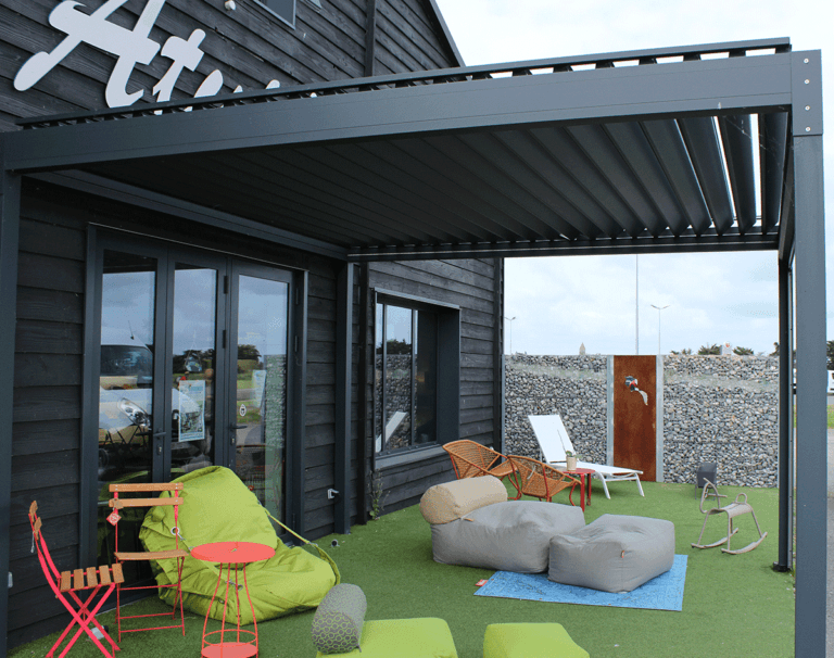 Pergola en bois bioclimatique avec salon de jardin coloré et jouets pour enfants