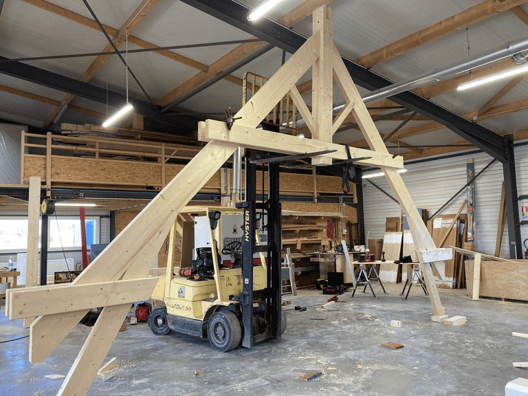 Assemblage d’une ferme à blochets en bois dans l’atelier Guilbaud & Fils à l’aide d’un chariot élévateur